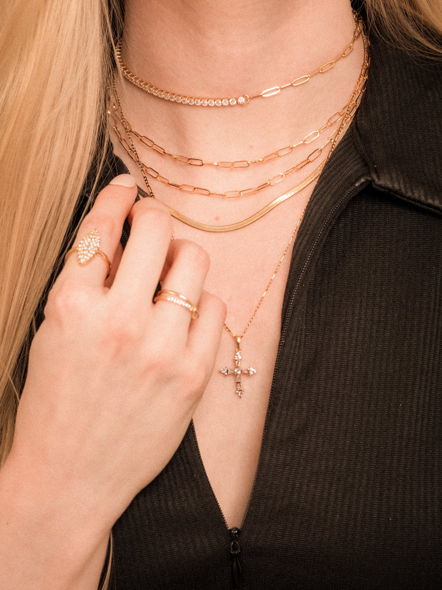 Woman in a black top wearing the Kinsey Designs Archives Wren Chain Layer 16k gold plated necklace, styled with rings and a cross pendant.