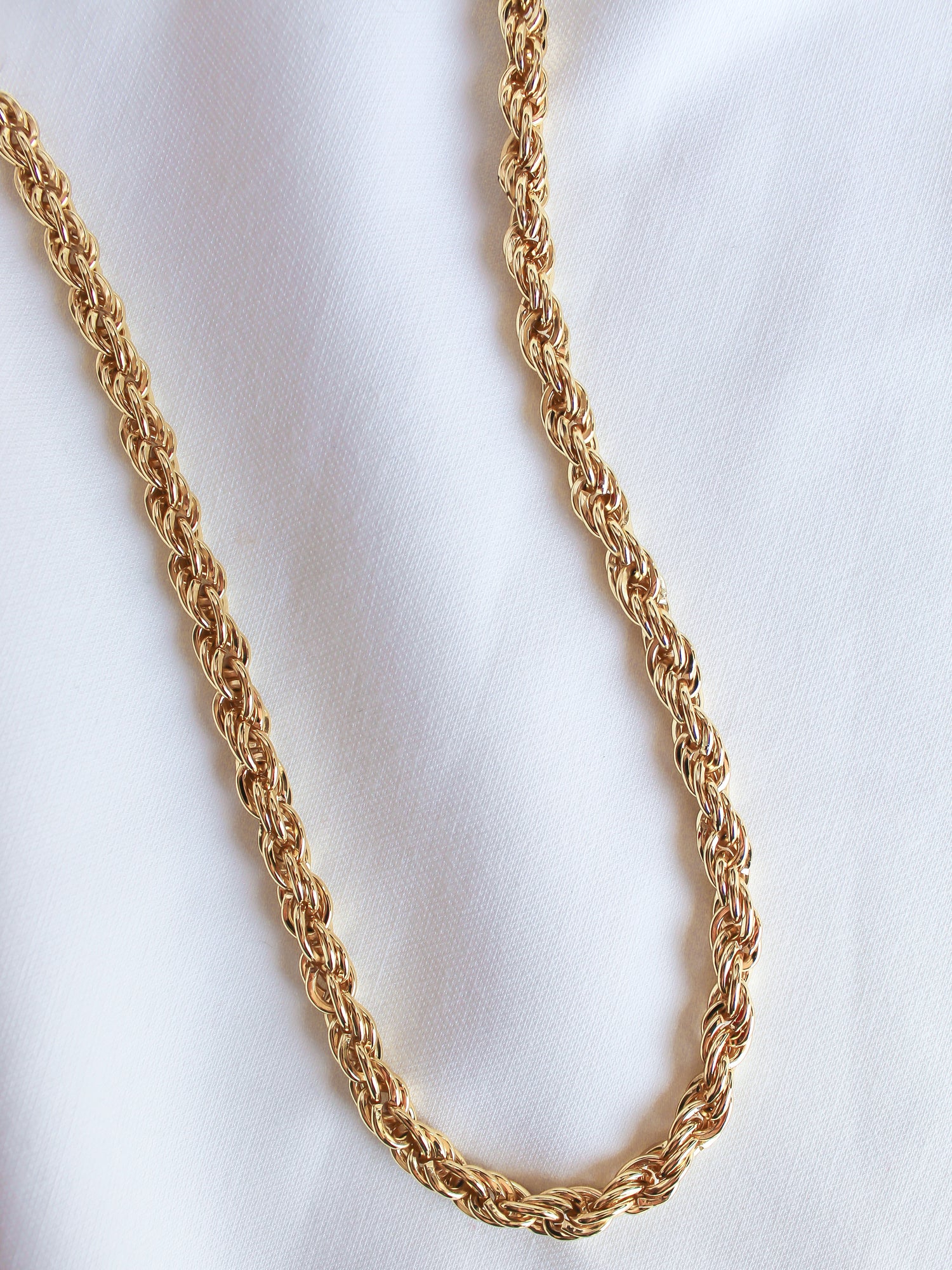 The Yacht Necklace by Kinsey Designs Archives, a 14k gold filled rope chain with an extender, rests elegantly on a white fabric background.