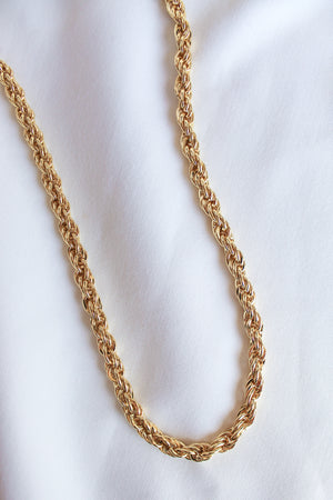The Yacht Necklace by Kinsey Designs Archives, a 14k gold filled rope chain with an extender, rests elegantly on a white fabric background.