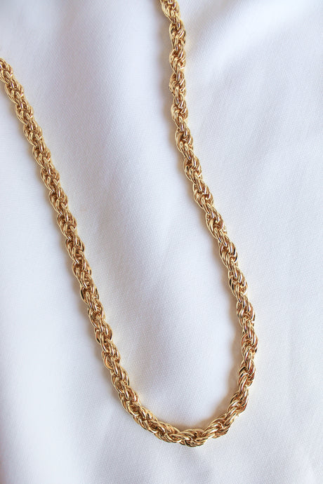 The Yacht Necklace by Kinsey Designs Archives, a 14k gold filled rope chain with an extender, rests elegantly on a white fabric background.