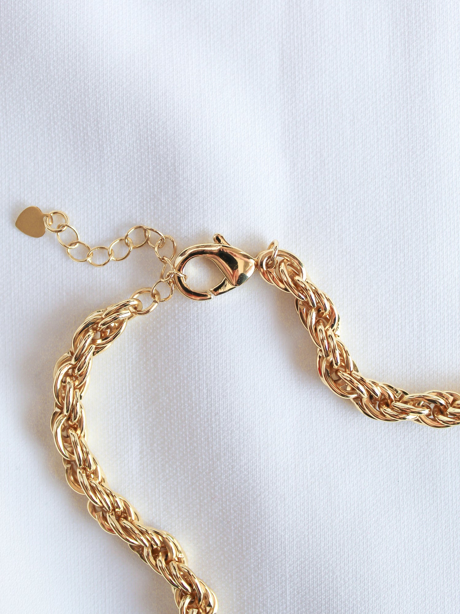 The Yacht Necklace by Kinsey Designs Archives, crafted in 14k gold fill with a lobster clasp and optional extender, is shown on a white fabric background.