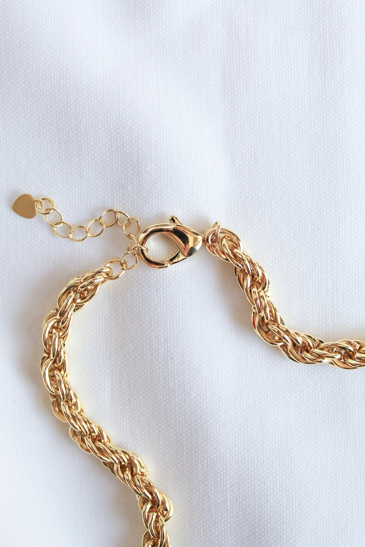 The Yacht Necklace by Kinsey Designs Archives, crafted in 14k gold fill with a lobster clasp and optional extender, is shown on a white fabric background.