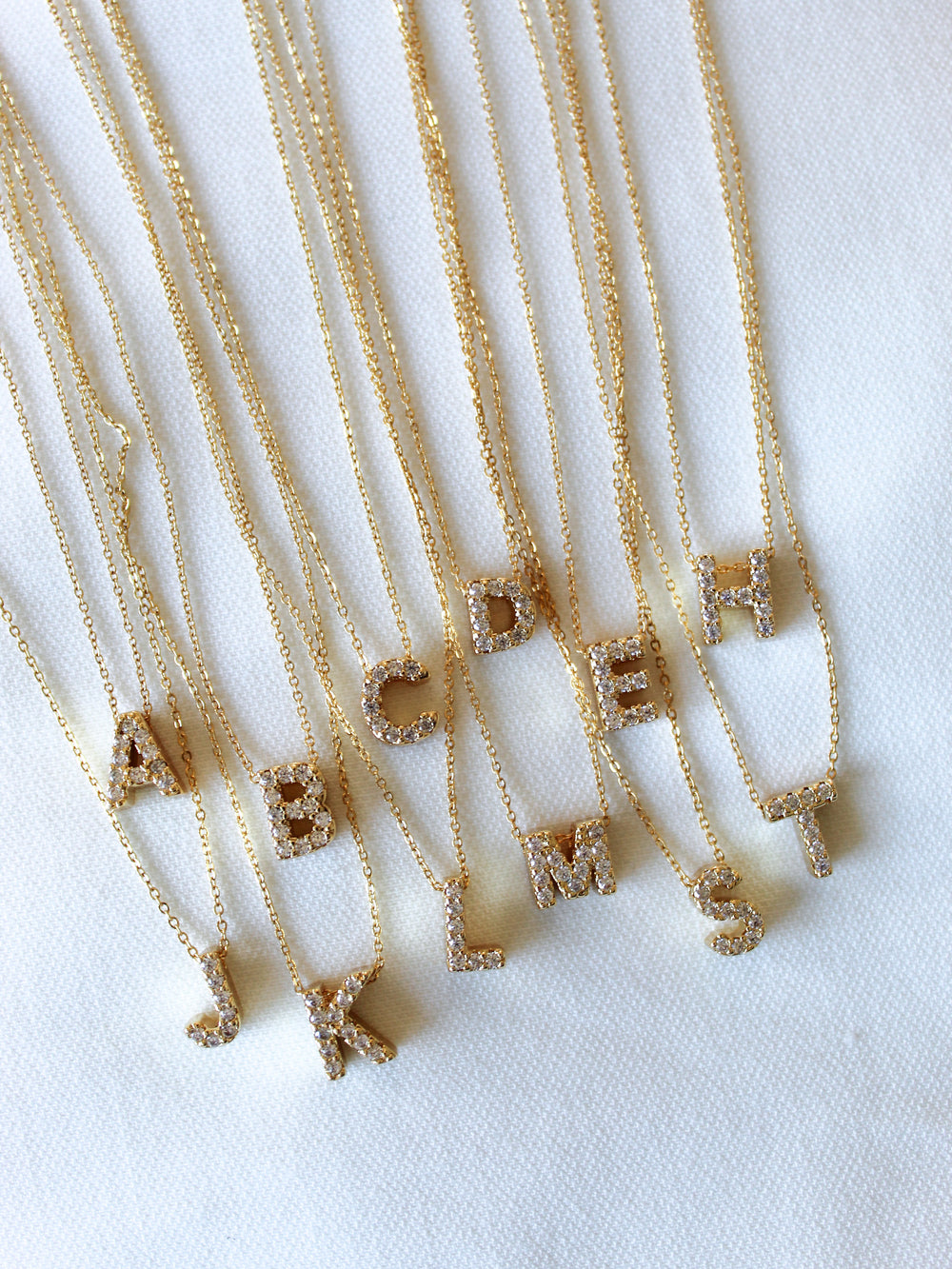 The Kinsey Designs Collection LUX Slide Initial Necklace Letter C is shown on a white fabric background.