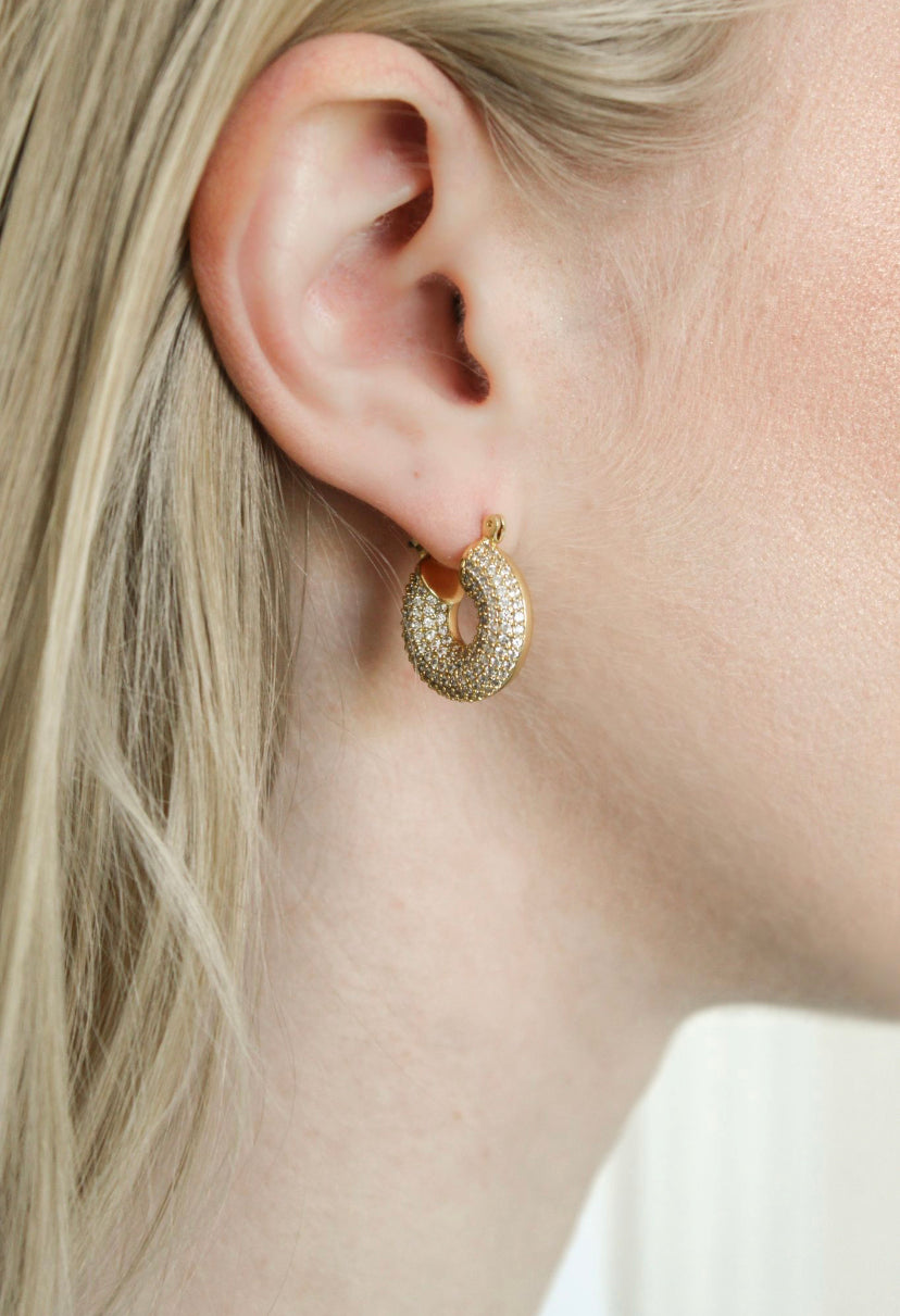 Close-up of a woman's ear wearing the Mikki Pave Hoop by Kinsey Designs Archives, a gold plated, textured hoop earring with sparkling details; measures .75" wide.