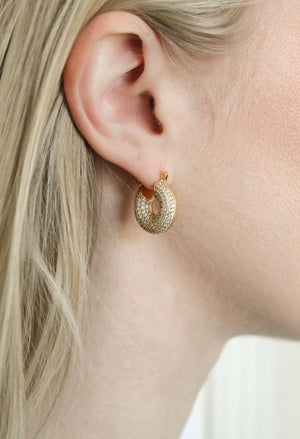 Close-up of a woman's ear wearing the Mikki Pave Hoop by Kinsey Designs Archives, a gold plated, textured hoop earring with sparkling details; measures .75" wide.