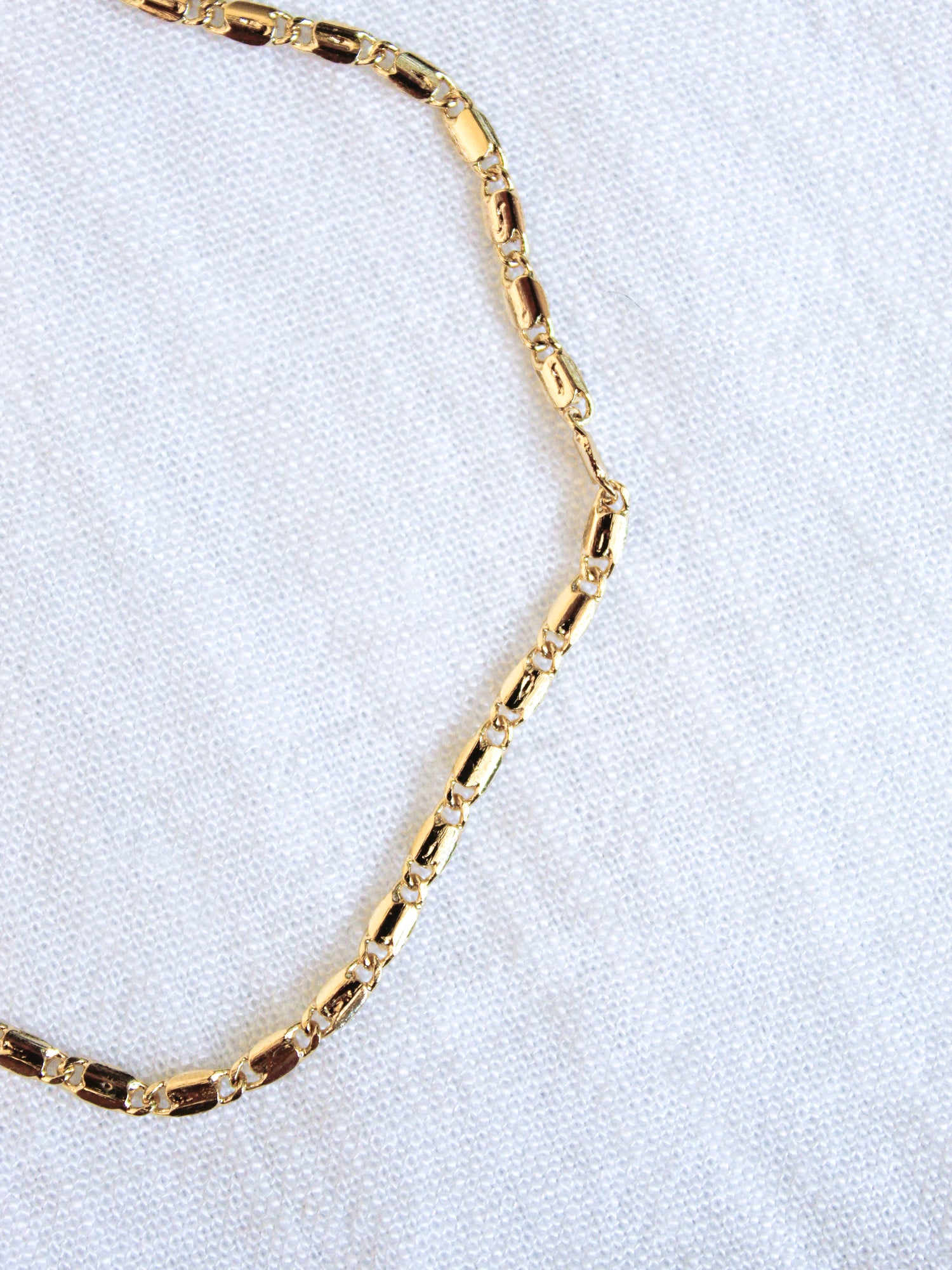 The Hali Anklet by Kinsey Designs Archives is displayed on a white textured fabric background, making it a perfect match with your favorite bracelet.