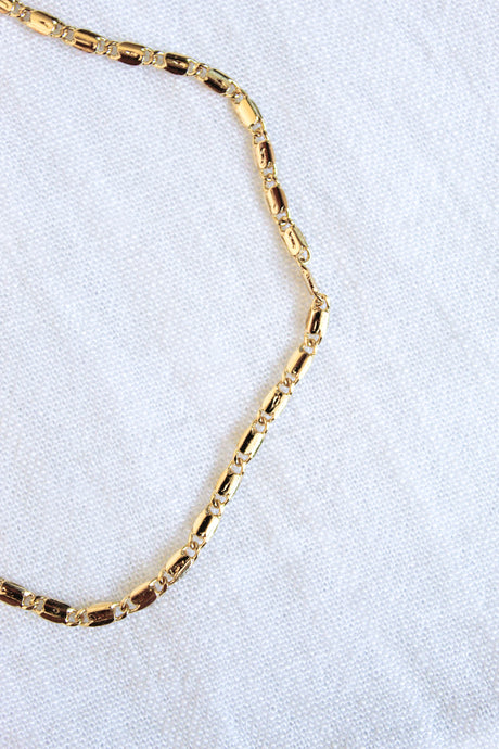 The Hali Anklet by Kinsey Designs Archives is displayed on a white textured fabric background, making it a perfect match with your favorite bracelet.