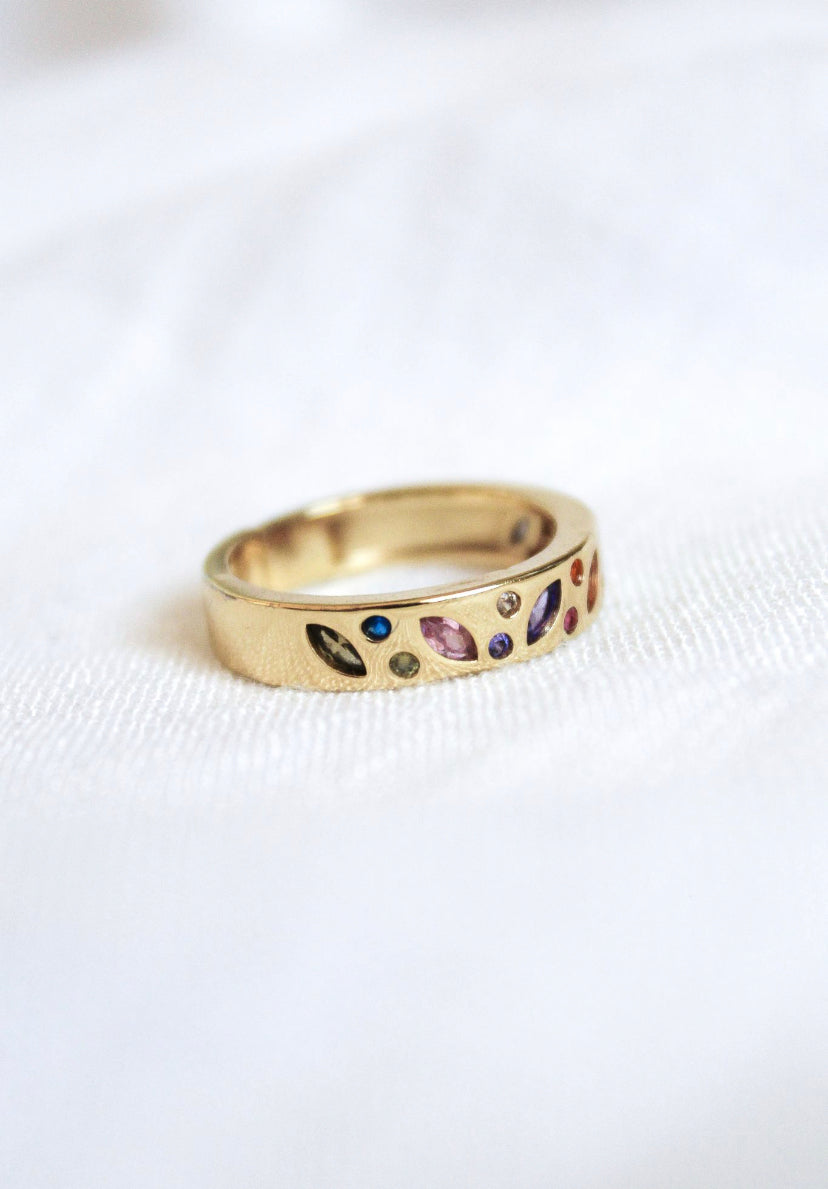 The Kinsey Designs Archives Luna Ring - Multi, a gold-plated size 7 ring with multicolored gemstones in varied shapes, rests elegantly on white fabric—an ideal sample sale find.