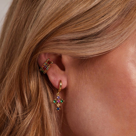 A close-up of a woman's ear wearing the Clementine Ear Cuff by Kinsey Designs Archives, featuring gold-filled metal and multicolored cubic zirconia gemstone flowers.
