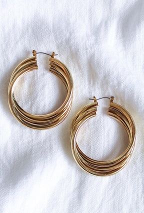 The Lexie Triple Hoop earrings by Kinsey Designs Archives feature gold-plated, intertwined loops and measure 2.25" long, shown on a white fabric background.