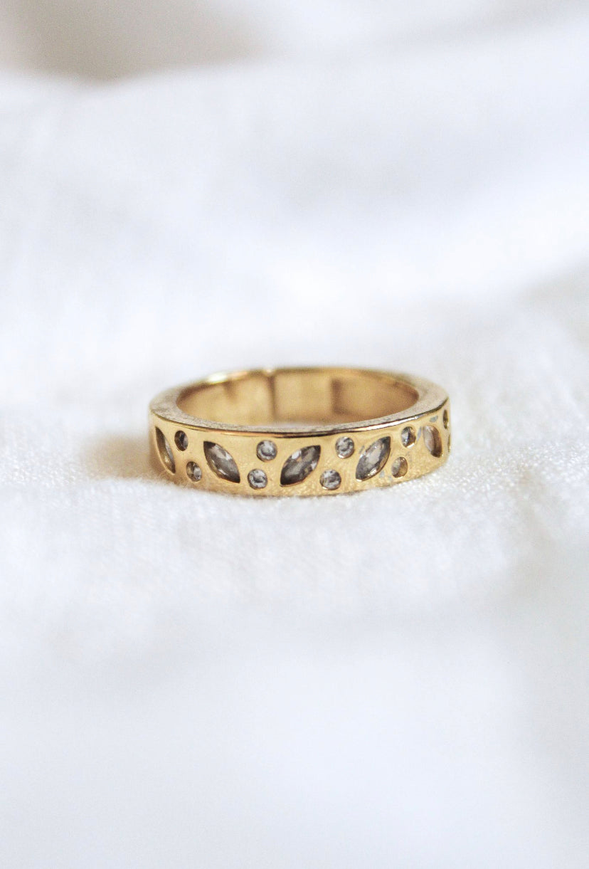 The Luna Ring - Multi by Kinsey Designs Archives features a leaf-pattern cutout and sparkling stones, size 7. Elegantly displayed on white fabric, it's perfect for anyone seeking style at a sample sale.