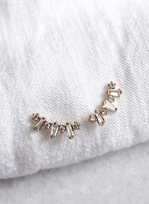 Irace Post gold filled earrings by Kinsey Designs Archives, featuring small clear cubic zirconia gems, shown on a soft white textured fabric background.