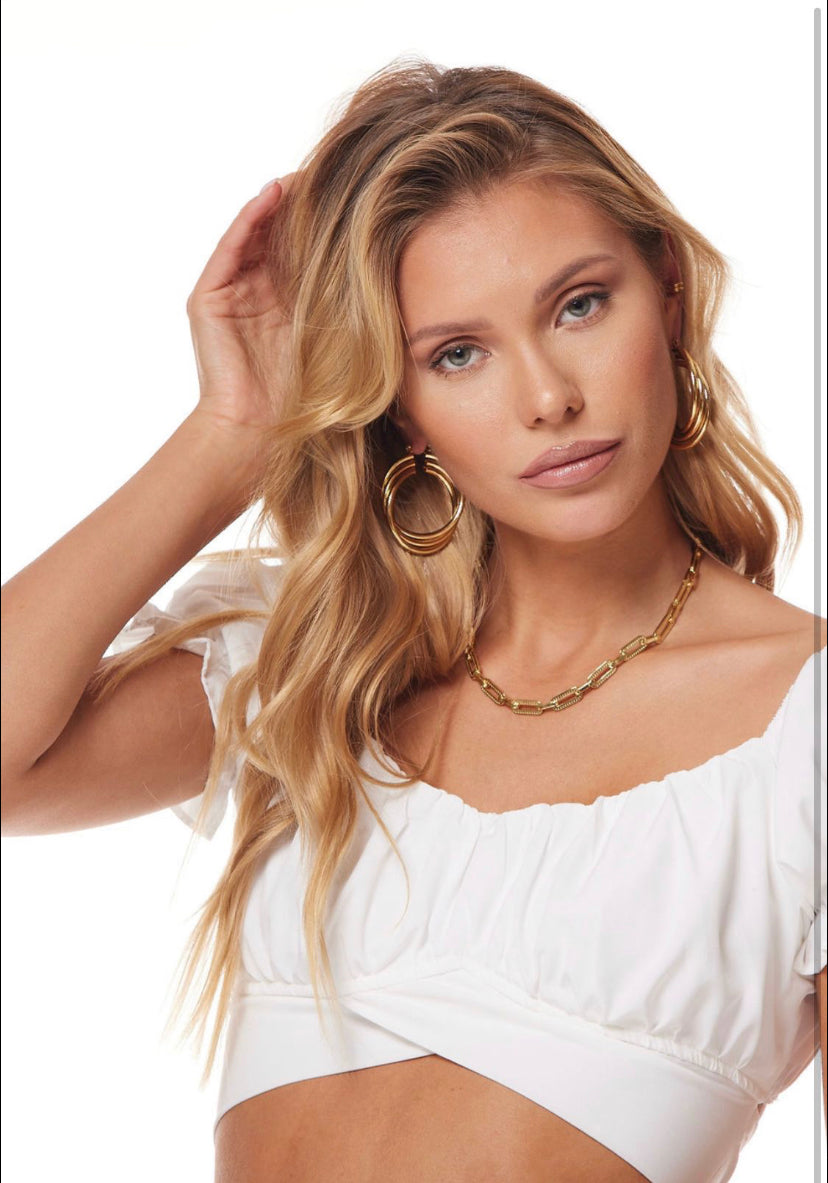 Woman with long blonde hair wears a white top, Kinsey Designs Archives Lexie Triple Hoop gold plated earrings (1.75" wide), and a gold chain necklace.