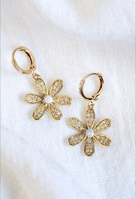 The Sandi Huggie by Kinsey Designs Archives features 16k gold plating, flower shapes with crystal petals and pearl centers, displayed on a white fabric background.