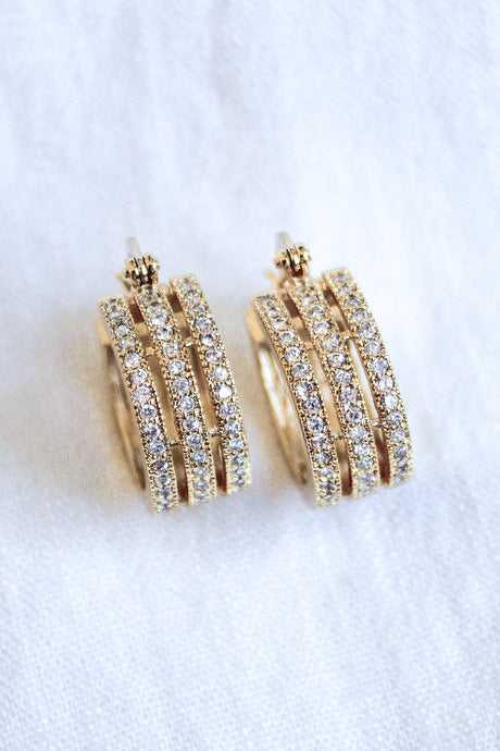 The Julia Triple Hoop by Kinsey Designs Archives features 1" gold filled hoops with three rows of sparkling cubic zirconia, shown on a white fabric background.