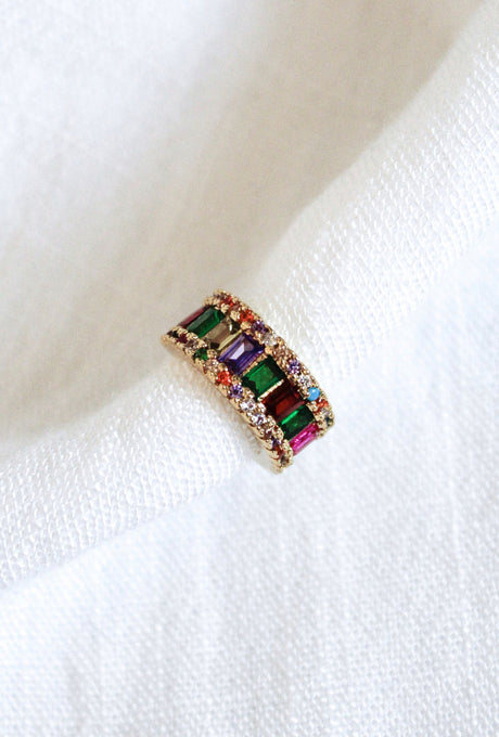 The Clementine Ear Cuff by Kinsey Designs Archives features multicolored rectangular gemstones and sparkling Cubic Zirconia, displayed on white textured fabric.