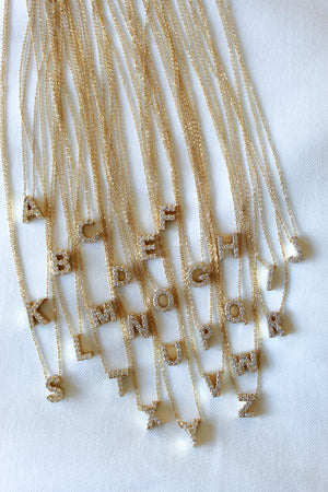 The Kinsey Designs Collection LUX Slide Initial Necklace features a sparkling letter G pendant displayed on a white surface.