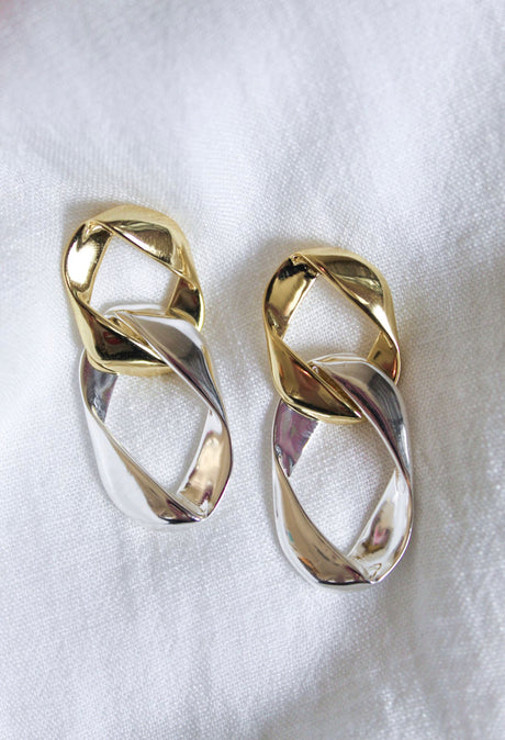 The Porter Earring by Kinsey Designs Archives features 2-inch gold and silver twisted links, 14k gold plated, shown on a white fabric background.